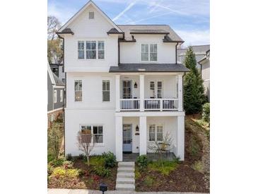 Charming two-story white home with a covered front porch and beautifully landscaped front yard at 5930 Brundage Ln, Norcross, GA 30071