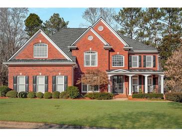 Charming two-story red brick home with a well-manicured lawn and beautiful landscaping at 5114 Parkwood Oaks Ln, Mableton, GA 30126