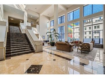 Bright lobby with high ceilings, marble floors, staircase, and large windows overlooking the city at 1280 W Peachtree Nw St # 2601, Atlanta, GA 30309