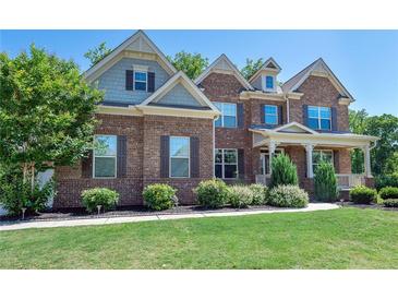 Charming two-story brick home with manicured lawn and inviting front porch at 6040 Ashborough Park, Cumming, GA 30040