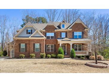 Charming two-story brick home with a cozy front porch and well-manicured landscaping at 6040 Ashborough Park, Cumming, GA 30040