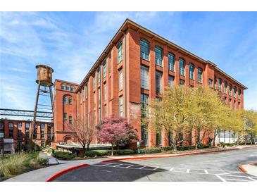 Beautiful brick building with large windows and water tower, set against a backdrop of mature trees and blue skies at 170 Boulevard Se # 127E, Atlanta, GA 30312