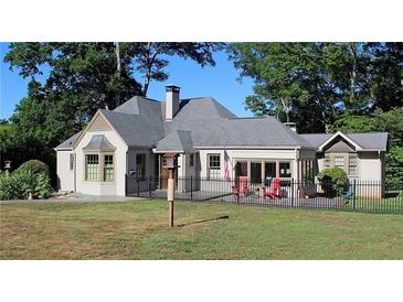 Charming single-story home with a manicured lawn and a classic iron fence surrounding the perimeter at 584 Cherokee Ne St, Marietta, GA 30060