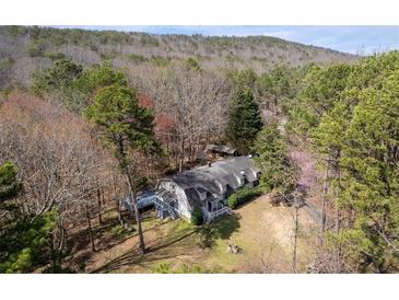 Secluded home nestled in a wooded area with a deck and charming architectural details at 231 Holly Springs Ne Rd, White, GA 30184