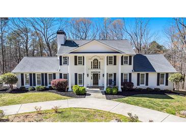 Stately white brick home featuring a columned front porch and manicured landscaping creating a welcoming curb appeal at 5430 Burdette Se Rd, Mableton, GA 30126