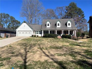 Charming two-story home featuring a well-maintained lawn, attached garage, and inviting front porch at 3750 Clubhouse Se Ln, Conyers, GA 30094