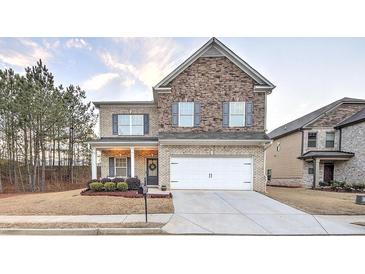 Charming two-story home featuring a brick and stone facade, a two-car garage, and a well-manicured front lawn at 125 Sunland Blvd, Mcdonough, GA 30253