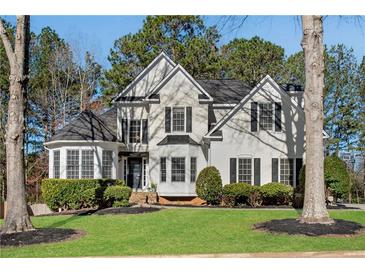 Charming two-story home with well-manicured lawn and mature trees creating a picturesque curb appeal at 3015 Foxhall Overlook, Roswell, GA 30075