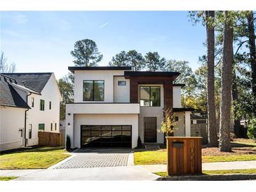 Modern two-story home with a glass garage door and professionally landscaped front yard at 1051 Wimberly Ne Rd, Brookhaven, GA 30319