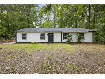 Charming ranch-style home featuring a modern exterior with a dark roof and black-framed windows at 2199 Blue Creek Ct, Conley, GA 30288