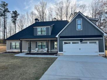 Charming single-Gathering home featuring a modern design with board and batten siding and a well-manicured lawn at 224 Crest Creek Way, Villa Rica, GA 30180