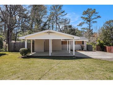 Exterior home view with carport, front lawn, and mature trees under blue sky at 2131 Columbia Dr, Decatur, GA 30032