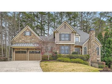 Stunning two-story home featuring a stone and siding exterior, two-car garage, and professionally landscaped yard at 2290 Dragonfly Nw Ct, Acworth, GA 30101