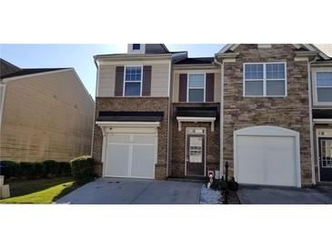 Charming townhome featuring brick and siding exterior, garage, and well-maintained landscaping at 2102 Executive Dr, Duluth, GA 30096