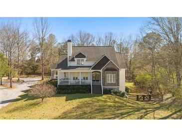 Charming home featuring a cozy front porch, stone accents, and mature trees at 129 Euharlee 5 Forks Rd, Euharlee, GA 30145