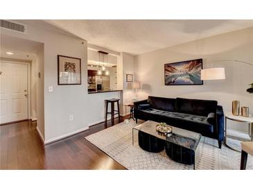 Inviting living room featuring hardwood floors, plush seating, and an open layout with a view into the kitchen at 275 13Th Ne St # 310, Atlanta, GA 30309