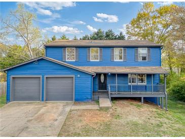 Charming blue split-level home featuring an attached garage and covered front porch at 2224 Bridle Ct, Norcross, GA 30071