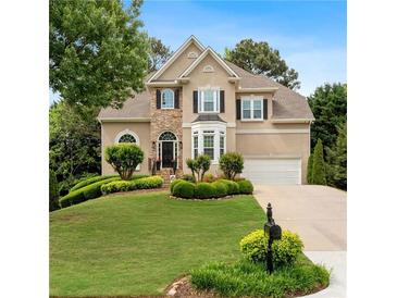 Charming two-story home featuring a stone facade, well-manicured lawn, and lush landscaping at 3640 Ridgeway Ter, Suwanee, GA 30024