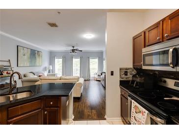 Open concept living space featuring a modern kitchen, hardwood floors, and abundant natural light at 5641 Roswell Rd # 307, Sandy Springs, GA 30342