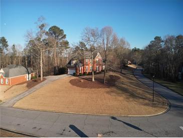 Traditional brick home with an attached garage and circular driveway on a landscaped lot at 5700 Thrasher Ln, Conyers, GA 30094