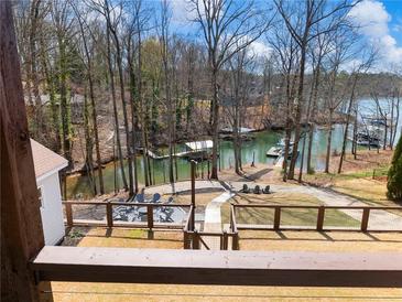 Beautiful backyard view with patio, fire pit and walkway to private covered dock on the lake at 6041 Blackberry Ln, Buford, GA 30518