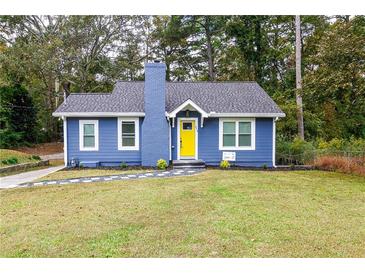 Charming blue home featuring a brick chimney, yellow door, and well-maintained landscaping at 578 Cedar Avenue, Atlanta, GA 30318