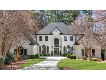 Stately two-story home featuring a manicured lawn and a circular driveway at 1112 Kensington Ct, Johns Creek, GA 30022