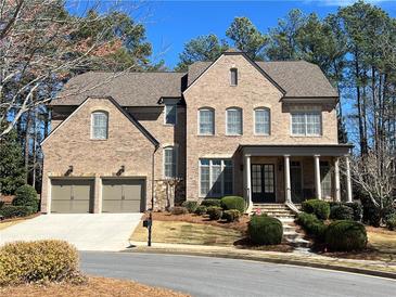 Charming two-story brick home featuring a two-car garage and well-manicured front lawn at 7920 Georgetown Cir, Suwanee, GA 30024