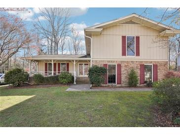 Charming home with manicured lawn, red shutters, and inviting front porch at 4833 Village North Ct, Atlanta, GA 30338