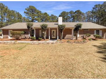 Charming single-story brick home with a well-maintained front yard and mature landscaping at 105 Creekwood Ln, Fayetteville, GA 30214