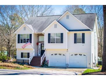 Charming two-story home with a two-car garage and an inviting front porch with American flag at 52 Newman Dr, Villa Rica, GA 30180