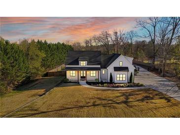 Beautiful modern farmhouse with black accents, a covered porch, and professionally landscaped front yard at 5241 Moon Rd, Powder Springs, GA 30127