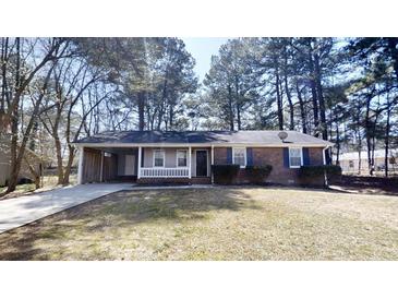 Charming one-story home with brick facade, covered entrance, and mature trees at 3359 Mansfield Ln, Snellville, GA 30039