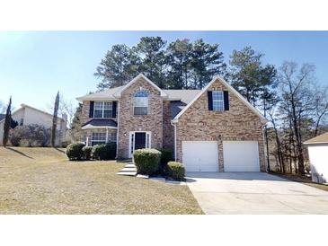 Charming two-story brick home with a two-car garage and well-manicured landscaping at 6643 Hill Creek Cv, Lithonia, GA 30058