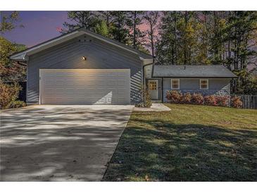 Charming home features a two-car garage, fresh landscaping, and a freshly sealed driveway at 284 Regal Dr, Lawrenceville, GA 30046