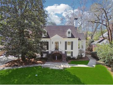 Charming white home with lush front lawn, mature trees, and a welcoming staircase entrance at 890 W Wesley Nw Rd, Atlanta, GA 30327