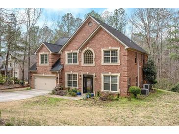 Charming two-story brick home with manicured lawn and attached garage at 1705 Butler Bridge Rd, Covington, GA 30016