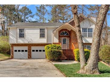 Charming two-story home with brick and white siding, complemented by a well-maintained front lawn at 713 Shore Ln, Lithonia, GA 30058