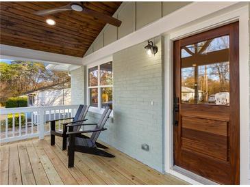 Inviting covered front porch with painted brick, wooden accents and stylish seating area at 1020 Pinedale Se Dr, Smyrna, GA 30080