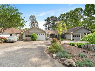 Charming home featuring a well-manicured front yard, two-car garage, and long driveway at 1126 Berkley Se Dr, Smyrna, GA 30082