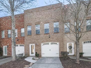 Charming brick townhomes featuring attached garages and well-maintained landscaping at 121 Riverwatch Ct, Canton, GA 30114