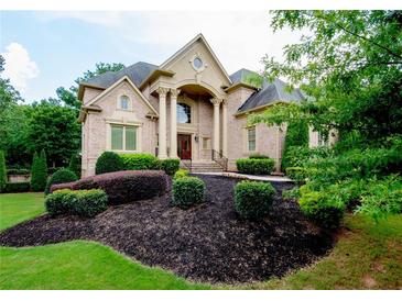 Elegant brick home featuring a landscaped front yard and classic architectural details at 3299 Carmichael Pl, Duluth, GA 30097