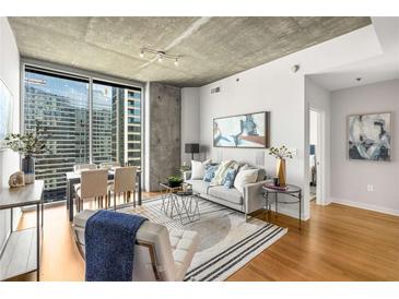 Bright living room with floor-to-ceiling windows offering city views and hardwood floors at 855 Peachtree Ne St # 1906, Atlanta, GA 30308