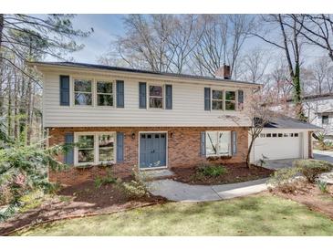 Charming two-story home featuring brick and siding with blue shutters and a manicured front yard at 2242 Greencrest Ne Dr, Atlanta, GA 30345