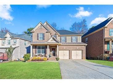 Charming two-story brick home featuring a welcoming front porch and a well-manicured lawn at 2591 Royston Dr, Duluth, GA 30097