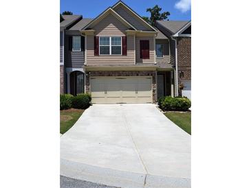 Traditional townhome with neutral siding, red shutters, a two-car garage, and a concrete driveway at 3356 Sardis Bend Dr, Buford, GA 30519