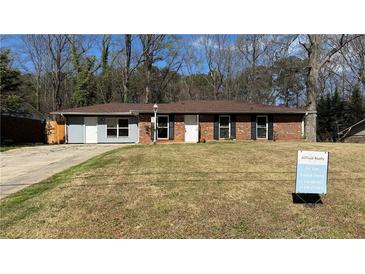 Charming single-story brick home with a well-maintained lawn and mature trees at 781 E Glochester Pl, Norcross, GA 30071