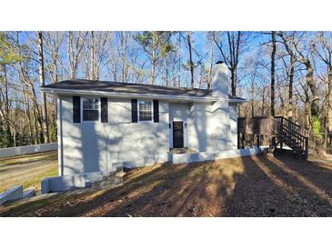 Inviting single-Gathering home featuring a neutral exterior, classic black shutters, and a cozy wooden deck at 2172 Nancy Way, Loganville, GA 30052