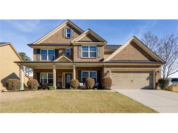 Charming two-story brick home featuring a well-manicured lawn and a welcoming covered front porch at 3475 Summerlin Pkwy, Lithia Springs, GA 30122