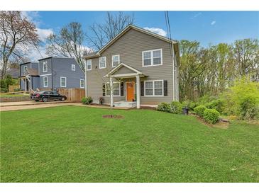 Charming two-story home with well-manicured lawn and welcoming orange front door at 1944 Lakewood Se Ter, Atlanta, GA 30315